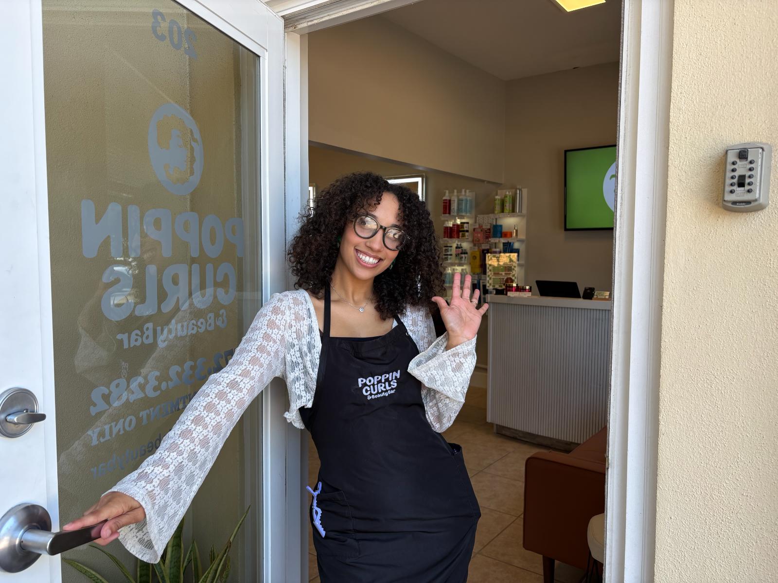 Curl stylist welcoming clients at Poppin Curls Beauty Bar in Port St. Lucie